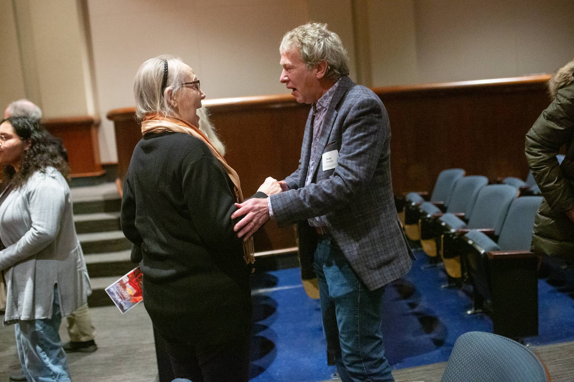 two people sitting on stage